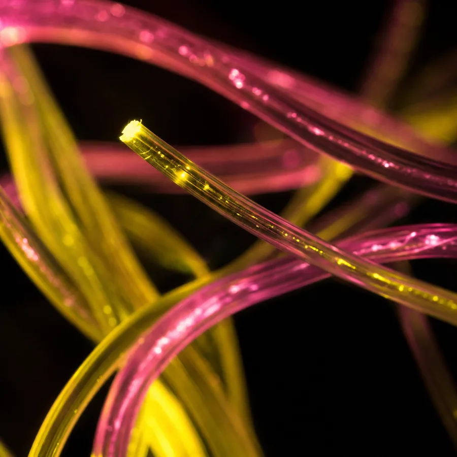 Verflochtene Glasfasern leuchten gelb und pink